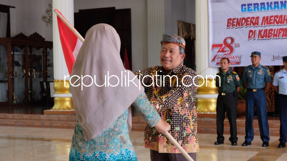 PEMBAGIAN - Kepala Badan Kesatuan Bangsa dan Politik (Bakesbangpol) Pemkab Sidoarjo, Dr Mustain Baladan membagikan bendera merah putih kepada perwakilan Organisasi Masyarakat (Ormas) di Pendopo Delta Wibawa, Kamis (20/07/2023). 
