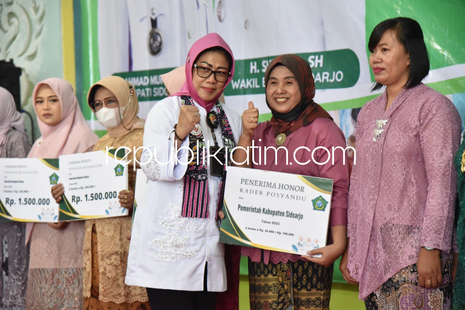 SERAHKAN - Kepala Dinas Kesehatan Sidoarjo, Dr Fenny Apridawati menyerahkan intensif untuk Nakes dan ratusan kader Posyandu di aula SMAN 1 Krembung, Rabu (02/08/2023).