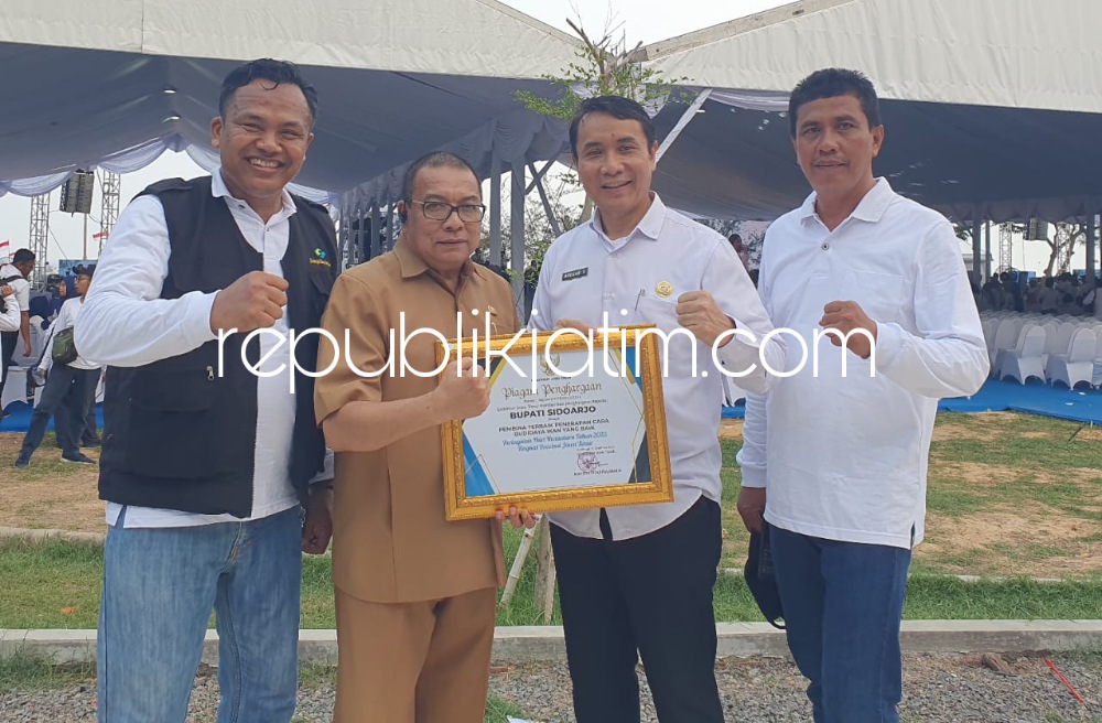 PENGHARGAAN - Pj Sekda Sidoarjo, Andjar Surjadianto dan Kepala Dinas Perikanan Pemkab Sidoarjo, Tjarda menunjukkan penghargaan yang diberikan Gubernur Jatim, Khofifah Indar Parawansa di Pantai Kenjeran, Surabaya, Senin (11/12/2023).