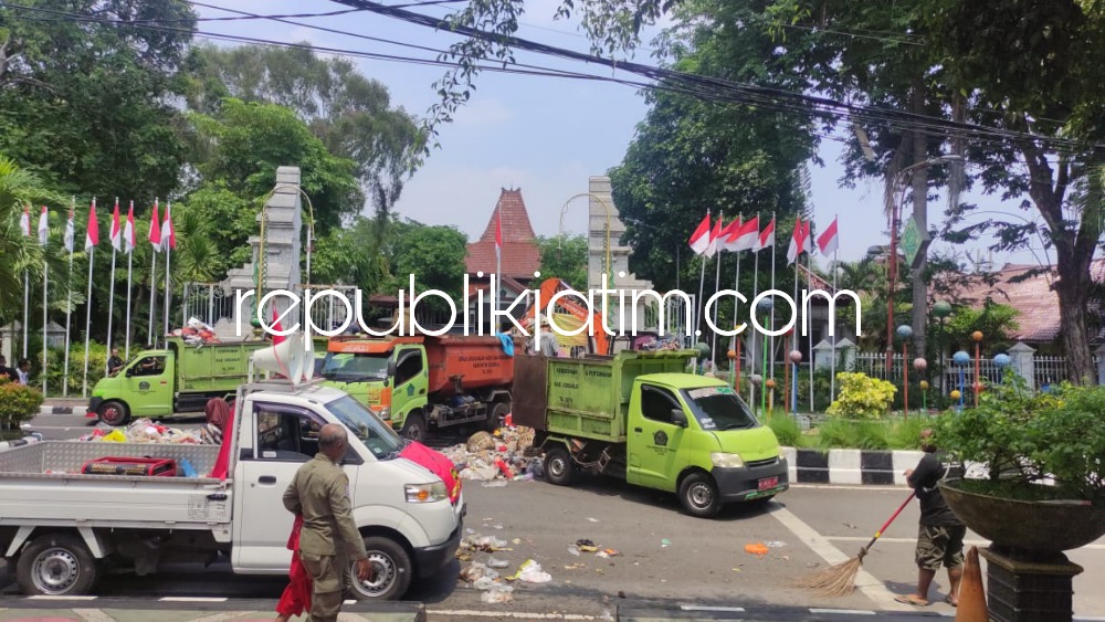 BERSIHKAN - Puluhan petugas kebersihan membersihkan tumpukan sampah yang dibuang pendemo di depan Pendopo Delta Wibawa dan Kantor DLHK Pemkab Sidoarjo, Rabu (20/12/2023) kemarin. 