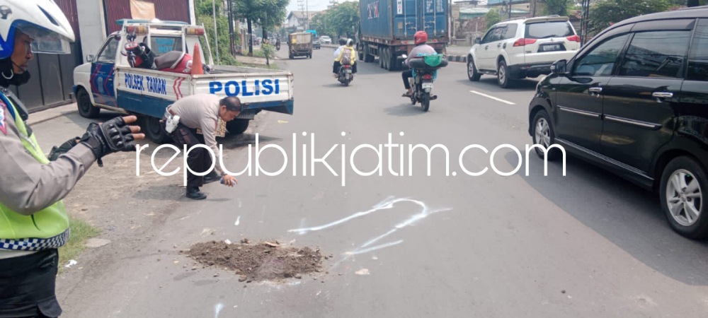 OLAH TKP - Sejumlah petugas Unit Gakkum, Satuan Lantas, Polresta Sidoarjo menggelar olah TKP dan mengevakuasi korban kecelakaan melibatkan dua motor dengan dump truk di JL Raya Taman, Sidoarjo, Sabtu (30/12/2023). 