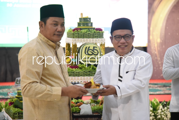 SYUKURAN - Wabup Sidoarjo Subandi menyerahkan potongan tumpeng syukuran Harjasda ke 165 kepada Ketua DPRD Sidoarjo Usman di Pendopo Delta Wibawa, Selasa (30/01/2024) malam.