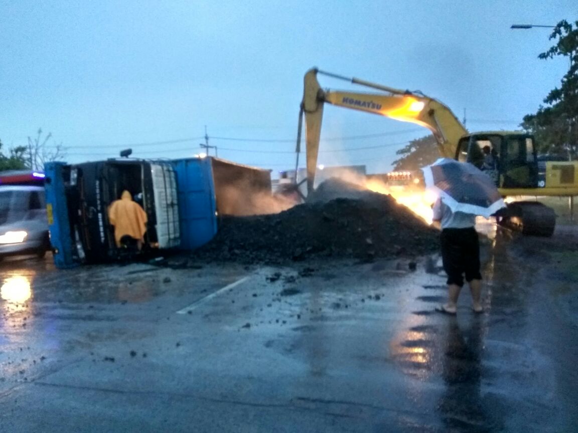 TERGULING - Sebuah dump truk bermuatan batu bara 35 ton yang dikemudikan Poniman (45) warga Kabupaten Pamekasan, Madura terguling di Exit Tol Porong, Sabtu (18/11/2017) petang.