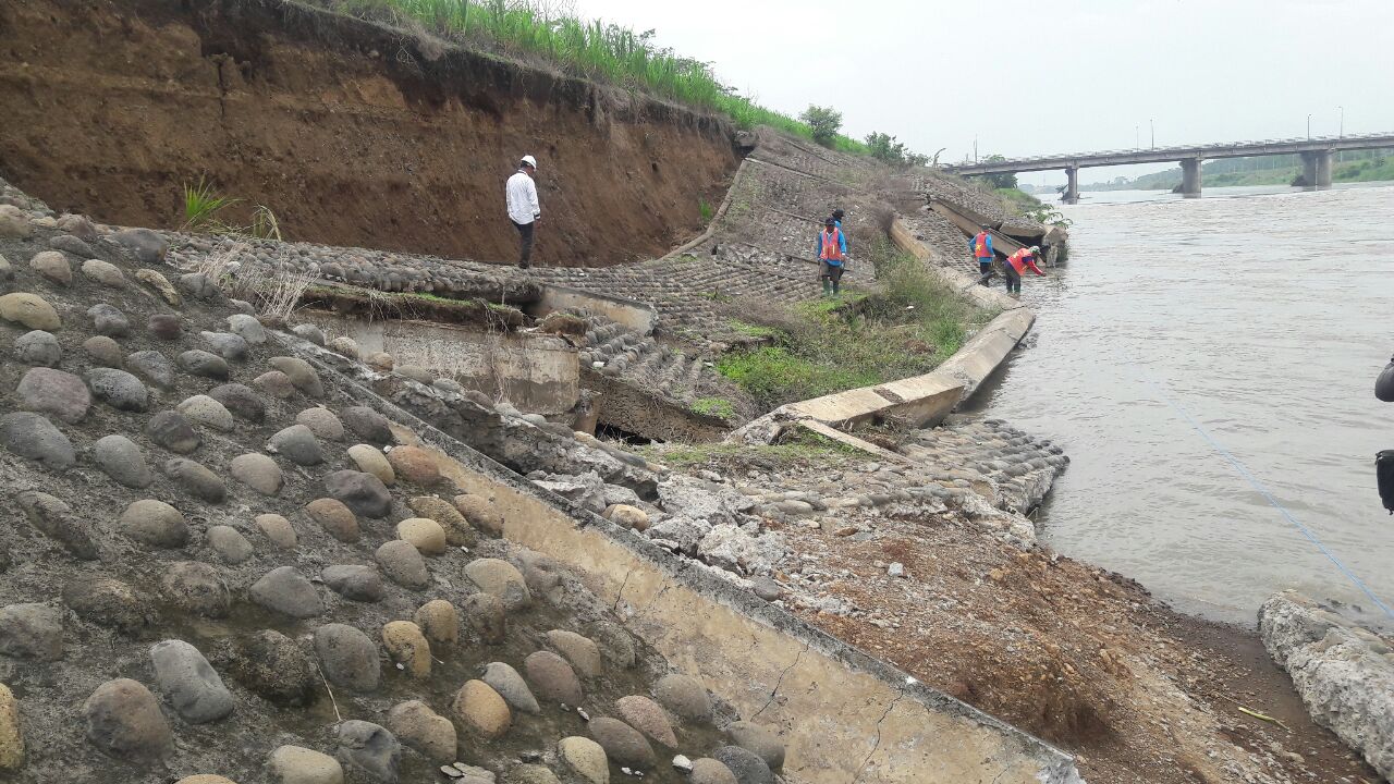 AMBROL - Sejumlah petugas Perum Jasa Tirta I sibuk membehani tanggul Sungai Porong yang ambrol sepanjang 50 meter dengan ketinggian 8 meter karena tergerus erupsi air, Rabu (22/11/2017).