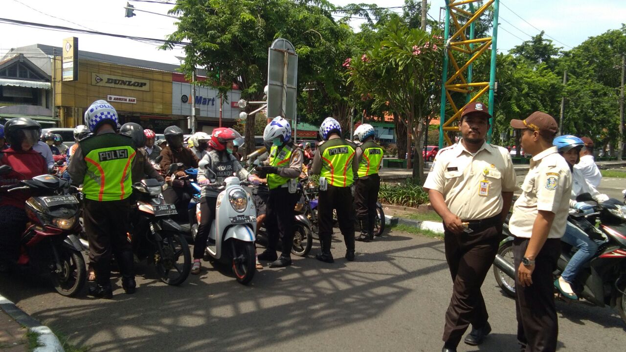 RAZIA - Petugas gabungan Satuan Lantas dan Dispenda menggelar razia kendaraan roda dua di depan GOR Sidoarjo, Rabu (22/11/2017).