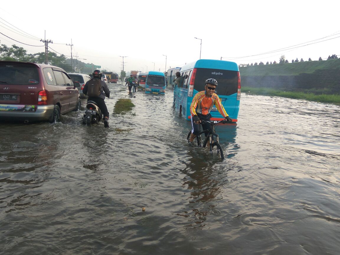 BANJIR - Jalan Raya Porong Lama terendam banjir setinggi lutut orang dewasa sejak, Minggu (26/11/2017) dini hari. Namun banyak roda dua dan empat memaksa menerjang banjir langganan setiap tahun itu lantaran terburu-buru hingga memicu kendaraan mogok.