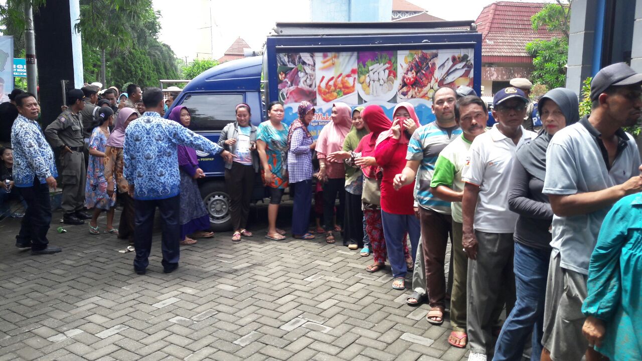 ANTRE - Ratusan warga antre di depan Kantor Dinas Kelautan dan Perikanan Pemkab Sidoarjo untuk mendapatkan kupon dan menebus bandeng Rp 12.500 per kilogram yang digelar setiap tahun dengan menyediakan 6 ton ikan bandeng, Rabu (29/11/2017).