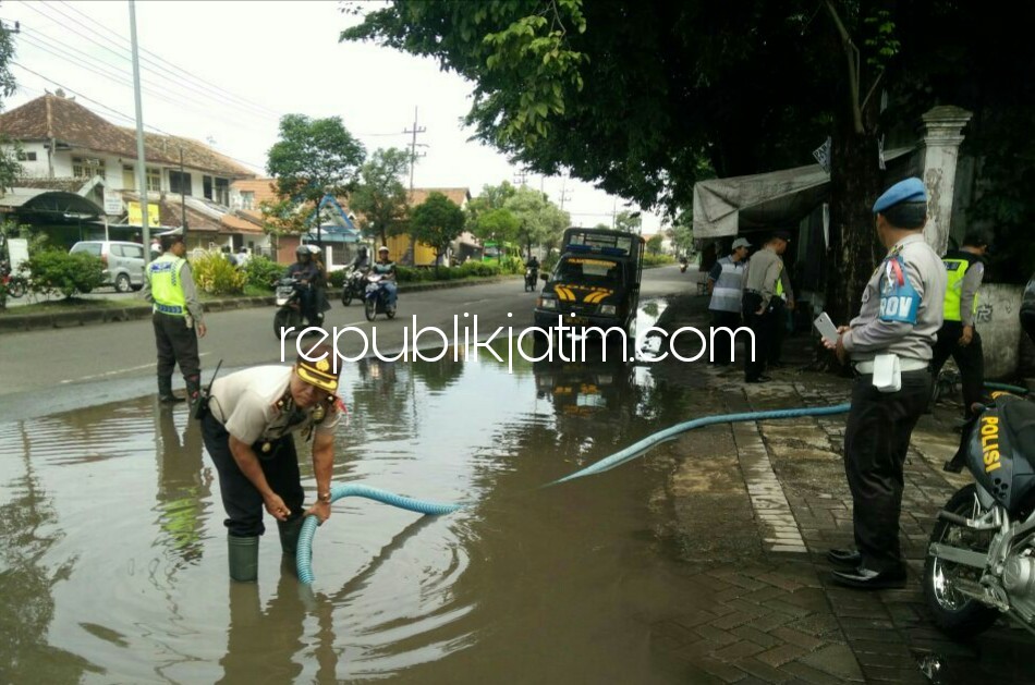 SEDOT GENANGAN - Kapolsek Tanggulangin, Kompol Sirdi memimpin penyedotan genangab air menggunakan mesin pompa beserta anggota Polsek Tanggulangin beserta aparatur desa Kalitengah bergotong-royong, Jumat (19/01/2018).