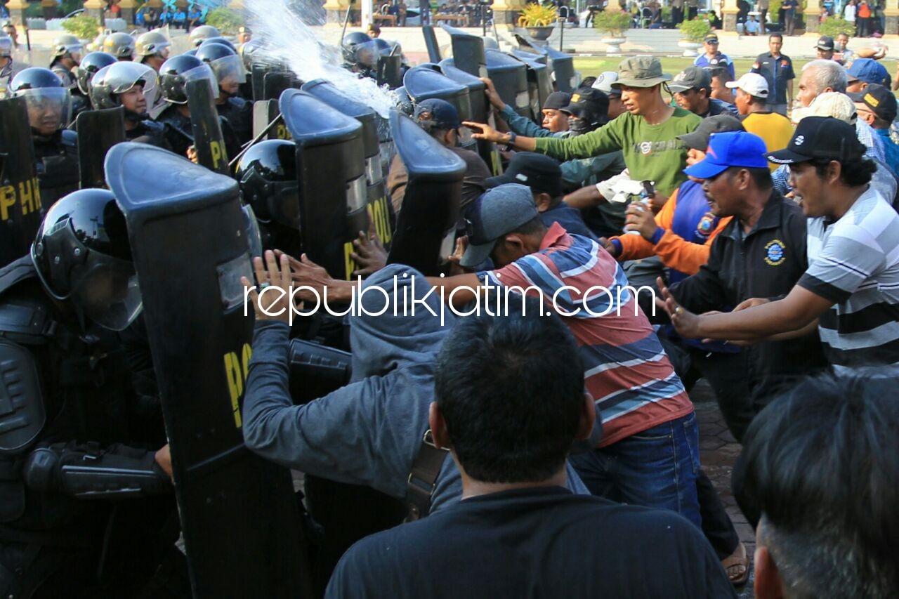 BENTROK - Anggota Polresta Sidoarjo yang mengamankan prosesi Pilgub Jatin bentrok dengan massa pendukung salah satu calon di Alun-Alun Sidoarjo, Minggu (18/02/2018) sore.