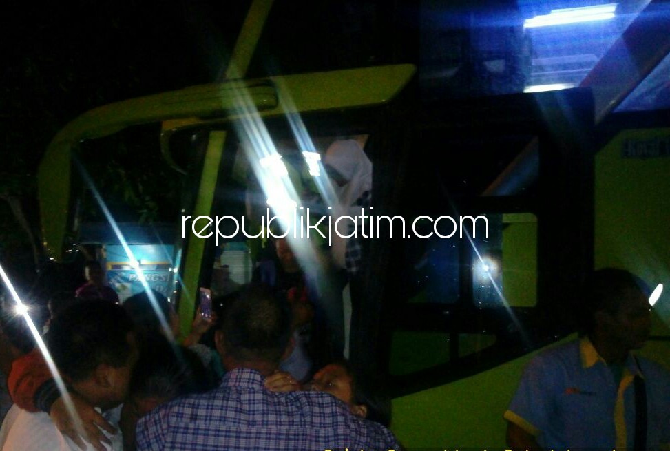 DISAMBUT - Kedatangan bus rombongan pengangkut siswa siswi SDN Wangkal, Kecamatan Krembung tiba di kampung halaman disambut isak tangis keluarga, Rabu (20/12/2017) malam.