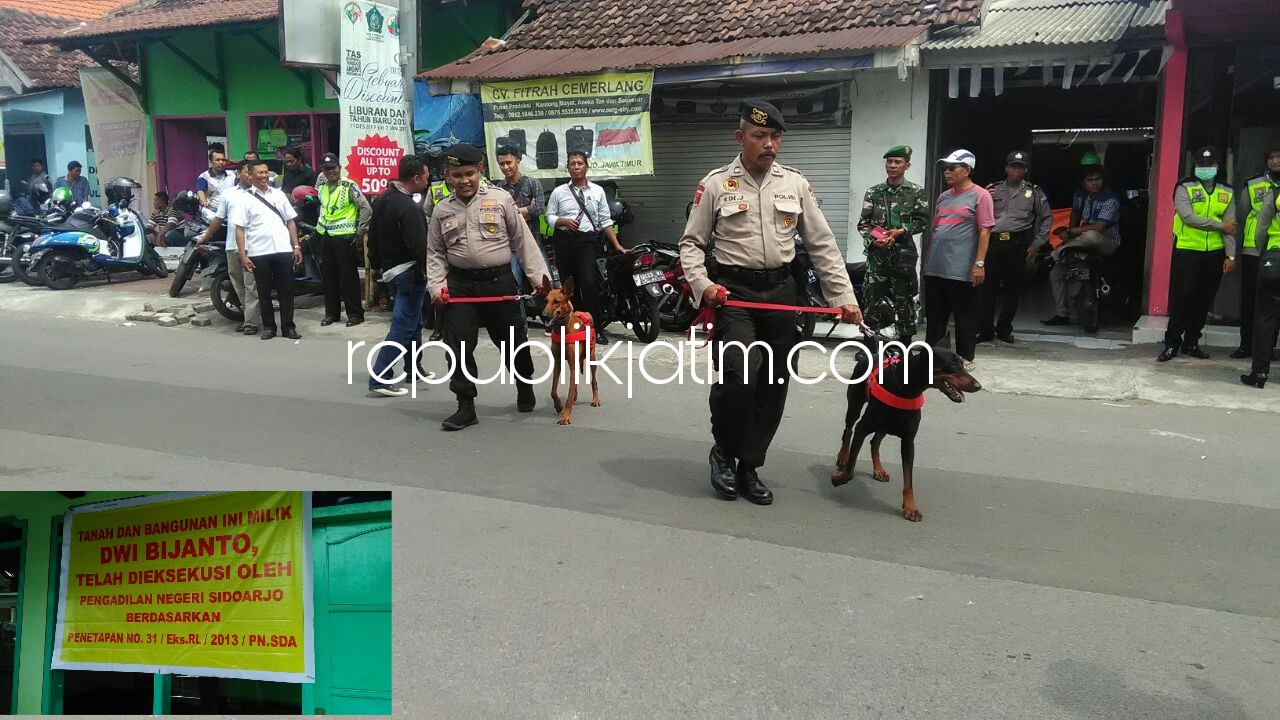 EKSEKUSI - Prosesi eksekusi yang dilakukan juru sita Pengadilan Negeri Sidoarjo terhadap rumah milik alm H Kusman di Desa Kedensari, Kecamatan Tanggulangin dijaga ketat petugas dan diterjunkan anjing pelacak, Rabu (27/12/2017).